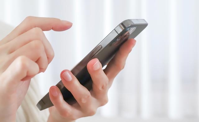 家族葬の四季風に電話でお問合せしようとしている人の手元。